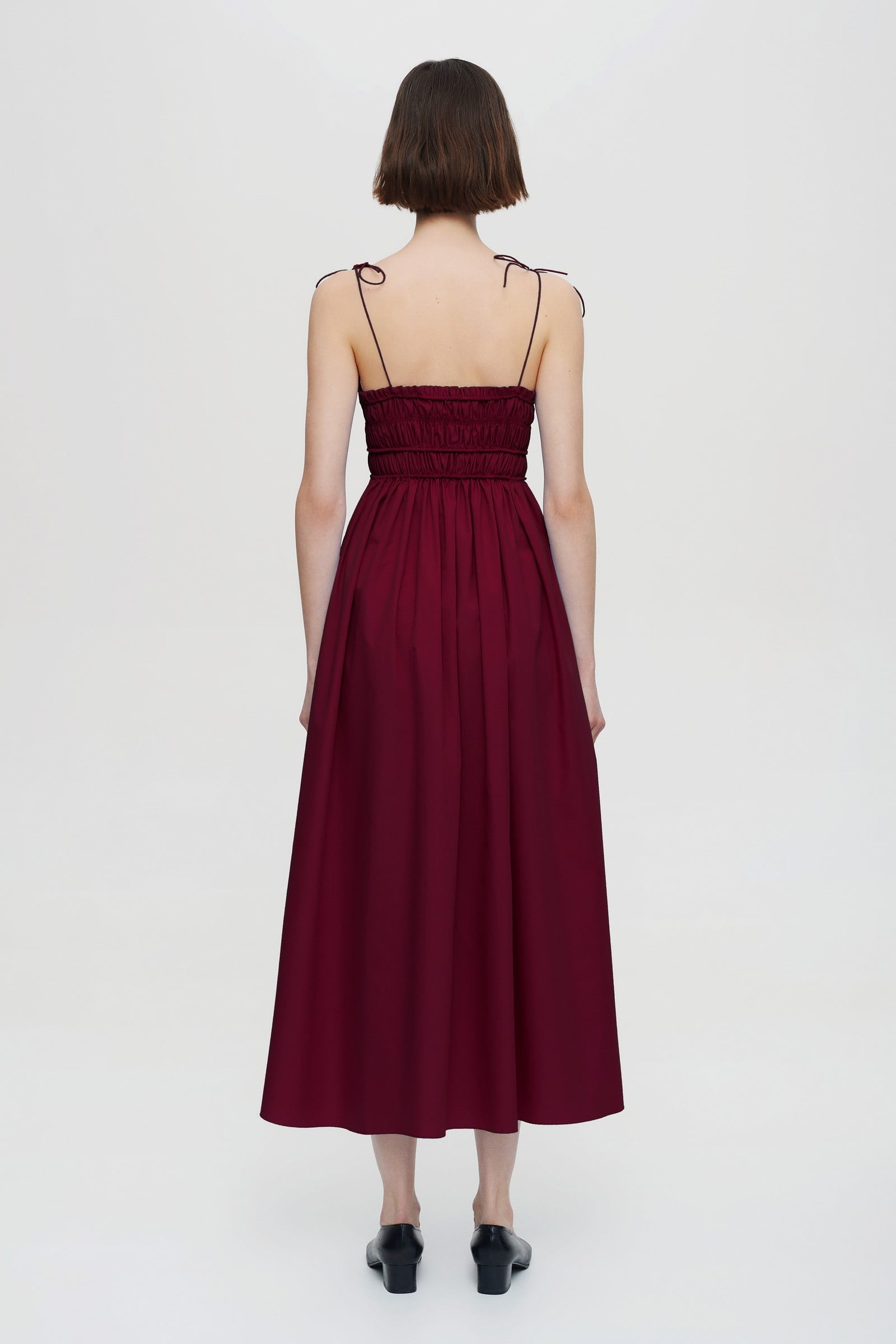 Model in pleated top midi Irresistible Flow dress back view