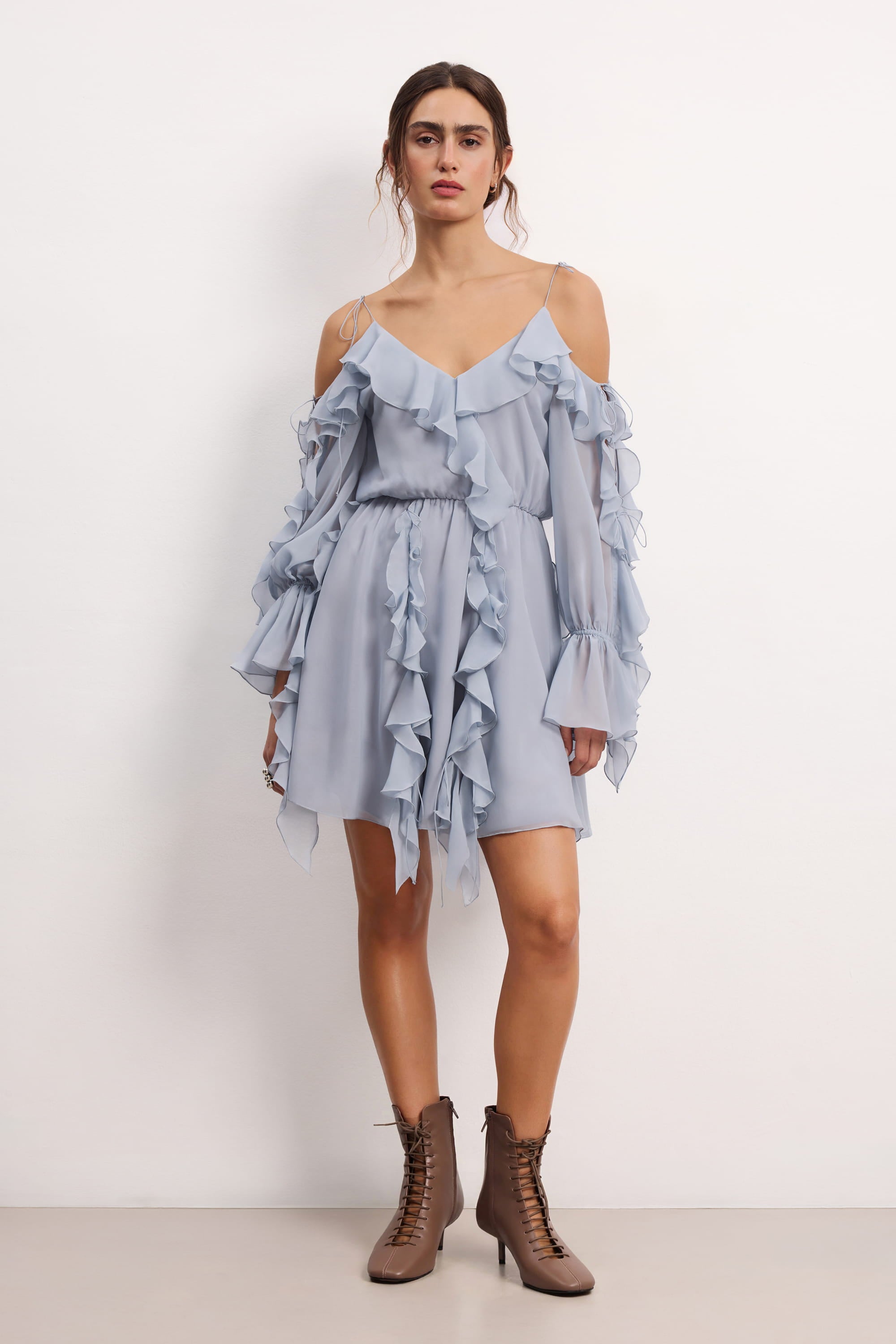 Woman wearing a blue fog off-shoulder ruffled Morning Forest mini dress on a white background, front view