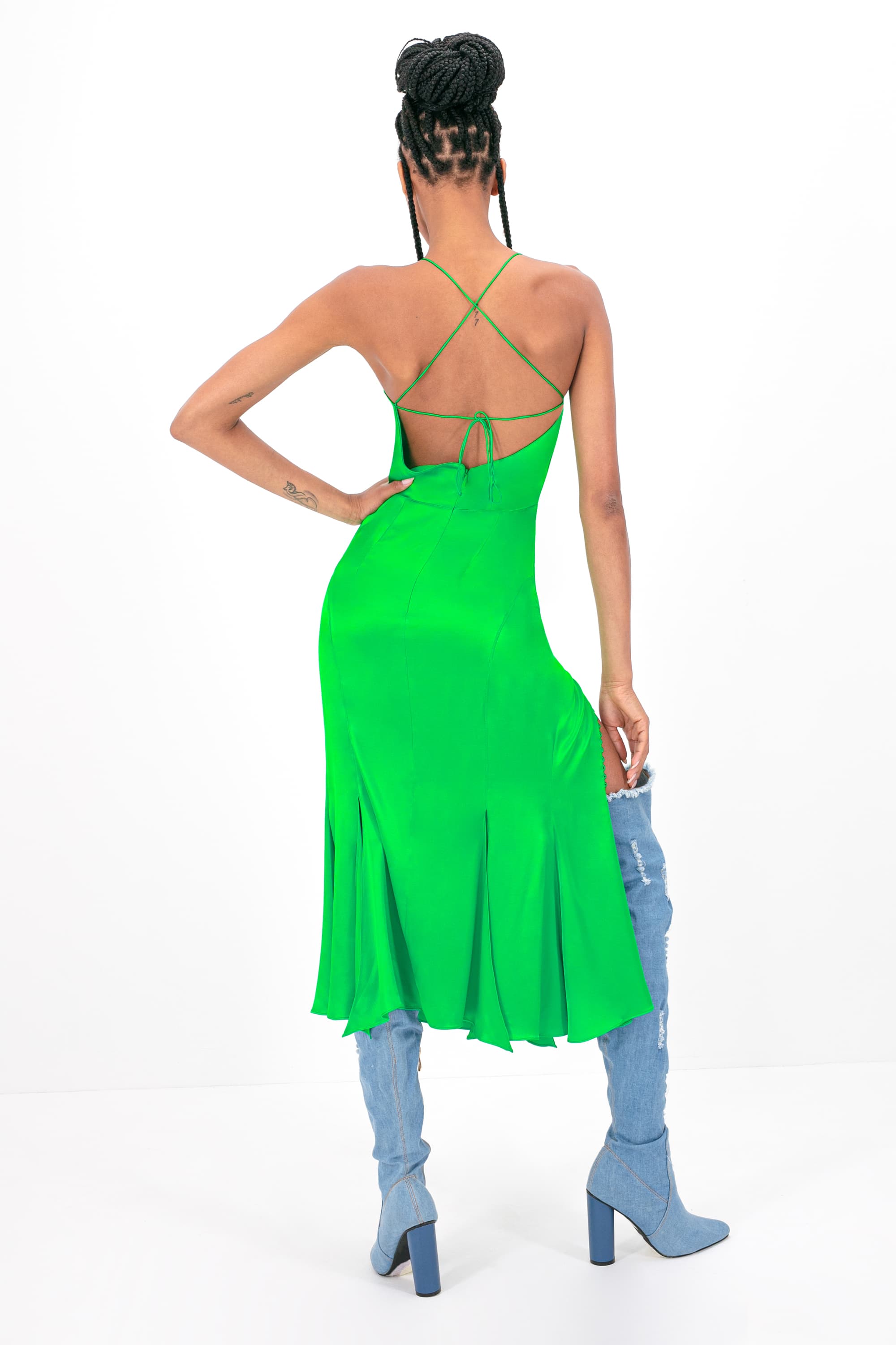Woman wearing green Andromeda dress standing against white background, back view, full length shot, full body