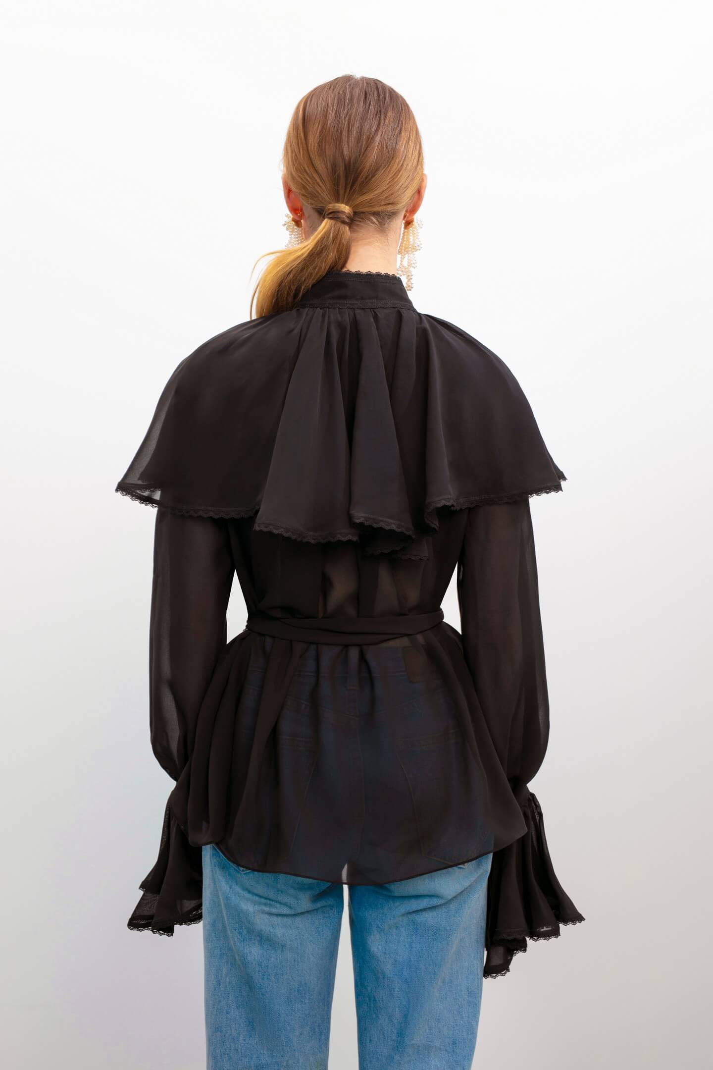 Model in Ocean Of Tenderness black blouse back view